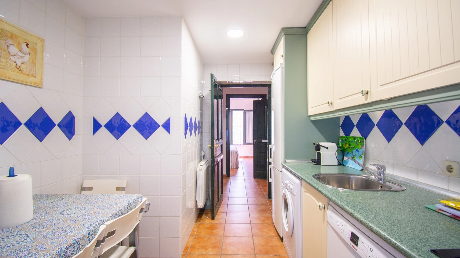 Cocina del apartamento La Fuentecilla, con azulejos blancos y azules. · Puerta del Agua
