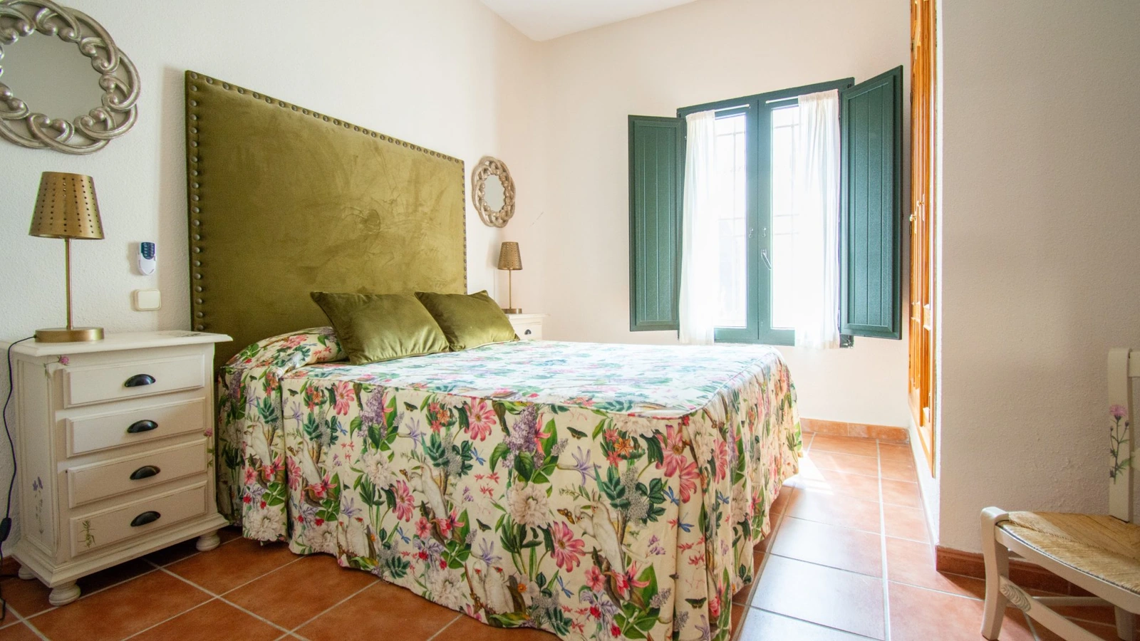 Dormitorio de La Mora Encantada con cabecero verde y ventana. · Puerta del Agua