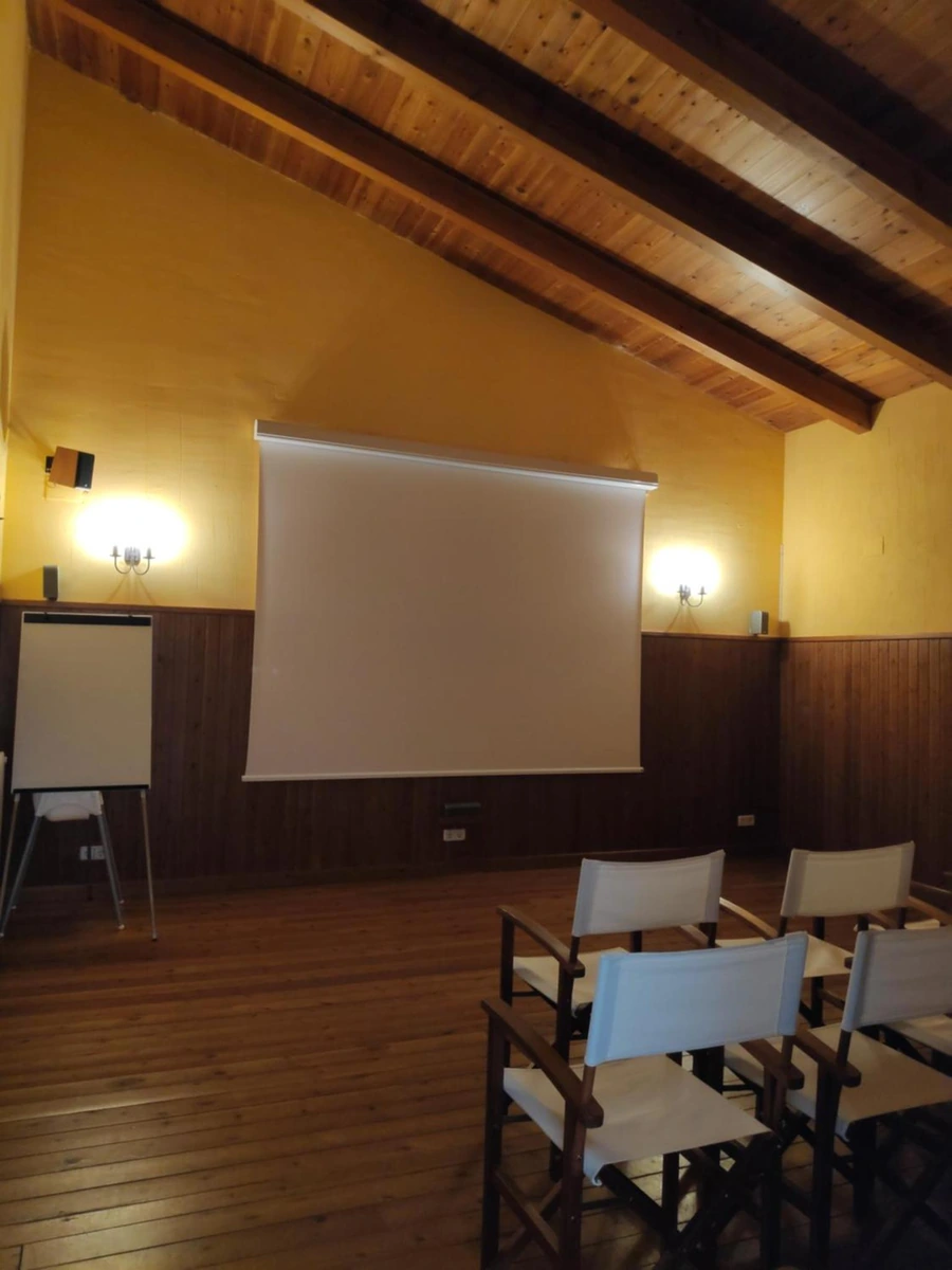 Sala de proyecciones con pantalla y sillas. · Tierras de Moya