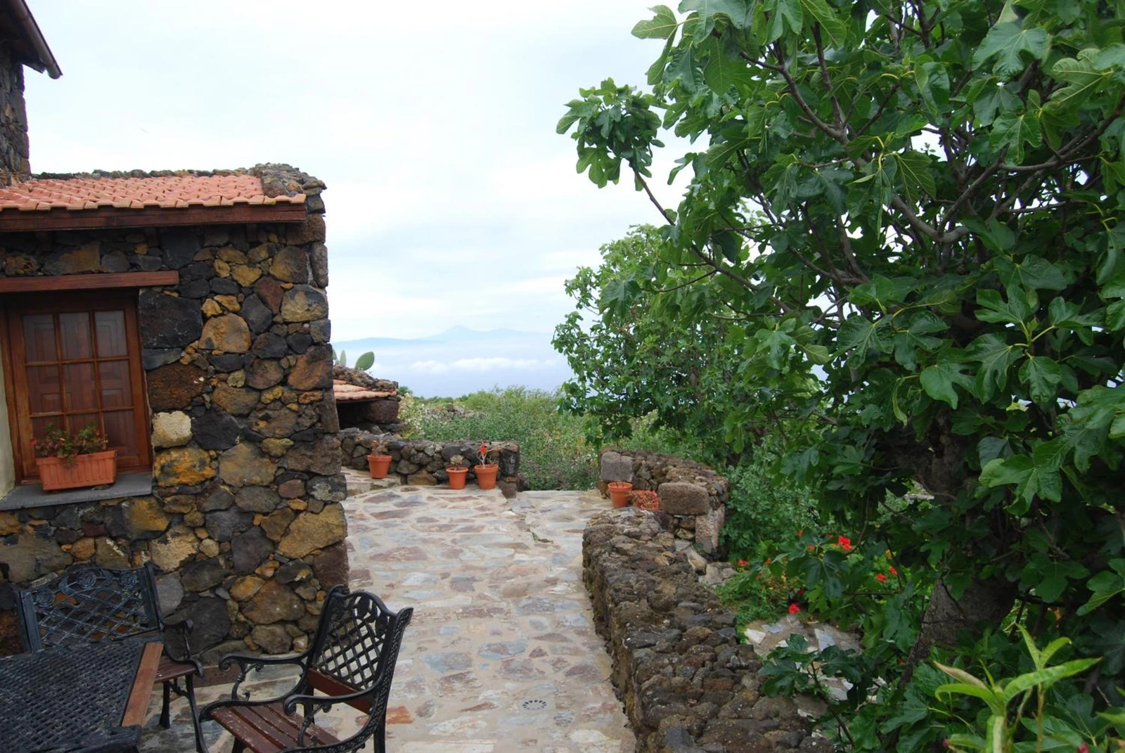 Patio con mesa y vistas desde la casa. · Casa Abuela Estebana