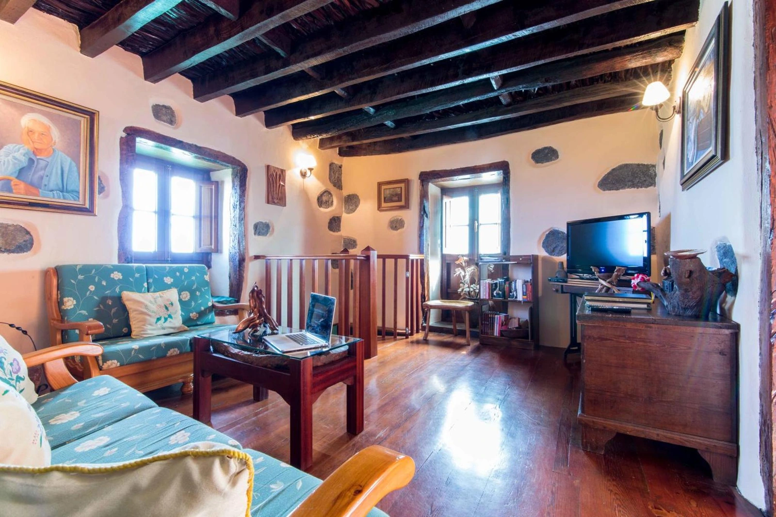 Salón con sofá, mesa y techo de madera. · Casa de mi Abuela María