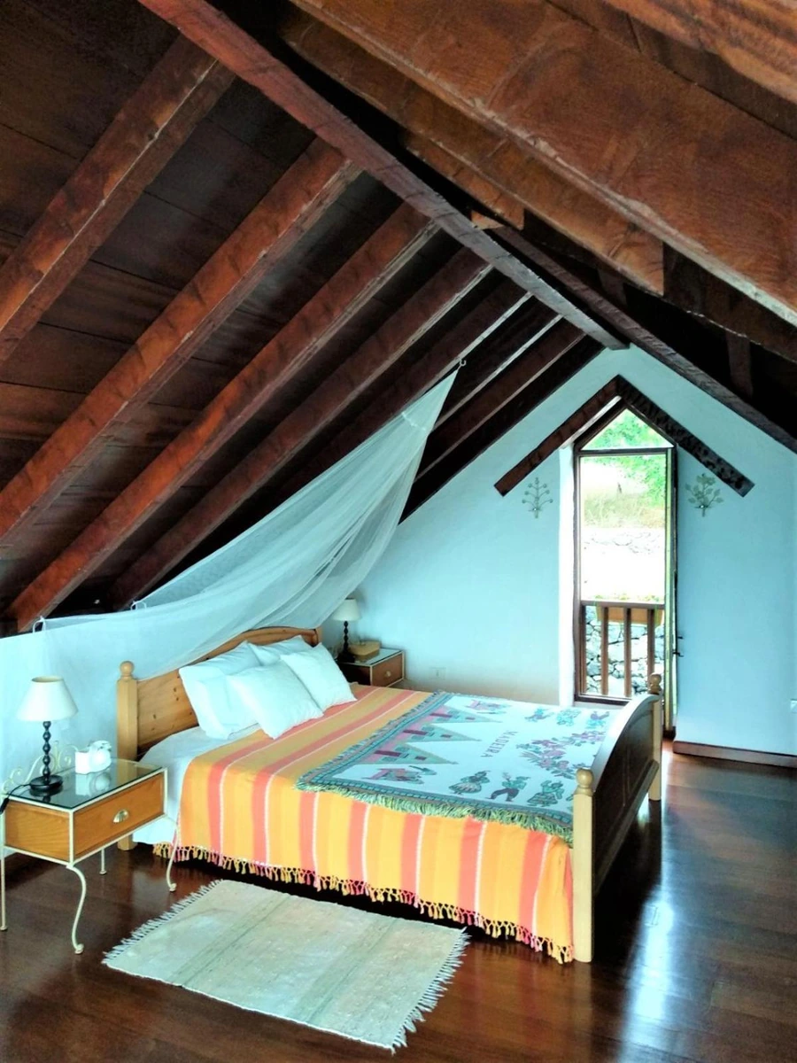 Dormitorio bajo cubierta con paredes azules. · Casa Rural Casa & Monte