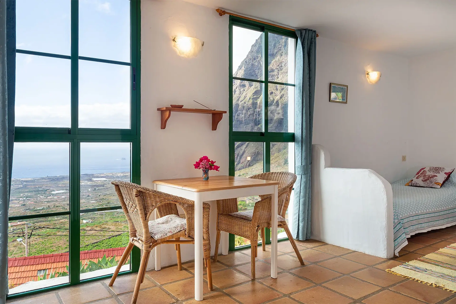 Interior de Sabinosa, con mesa junto a los ventanales y zona de descanso a la derecha. · El Sitio