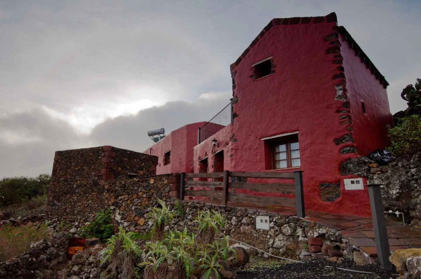 Exterior rojo de la casa compartida de Jirdana. · Casas Rurales Poblado Jirdana
