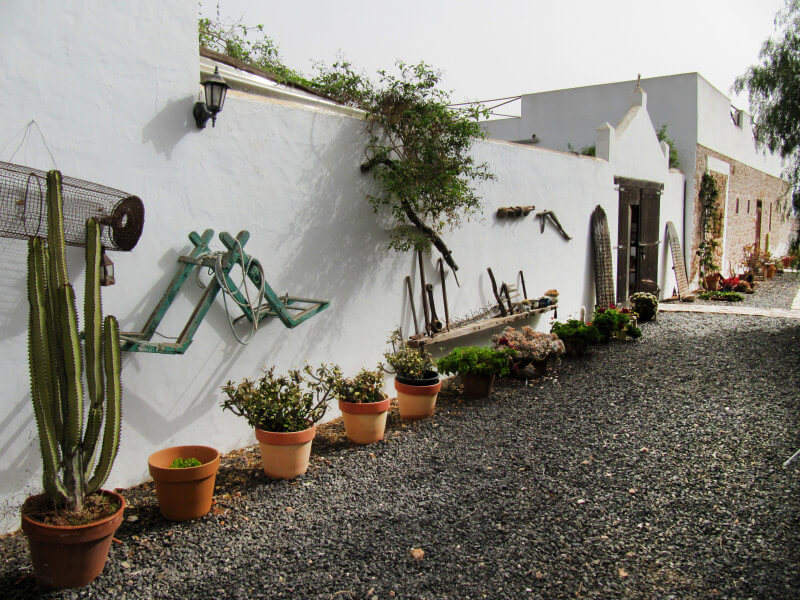 Camino ajardinado junto a la fachada tradicional · Hotel Rural Era de la Corte