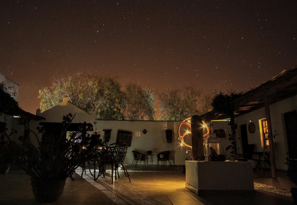 Patio del hotel iluminado bajo el cielo nocturno · Hotel Rural Era de la Corte