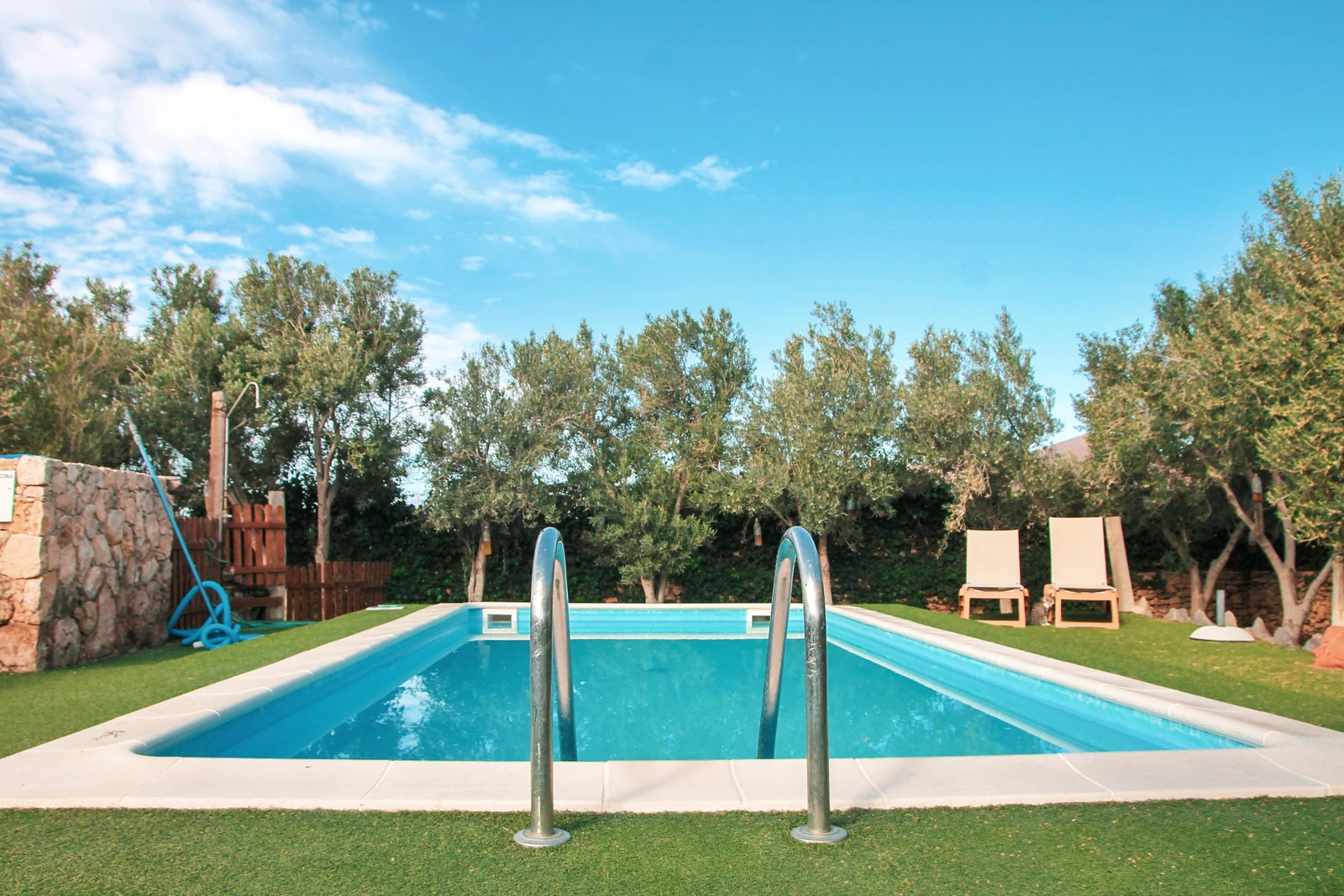 Piscina exterior compartida de La Gayria, rodeada de jardín. · Agroturismo La Gayría