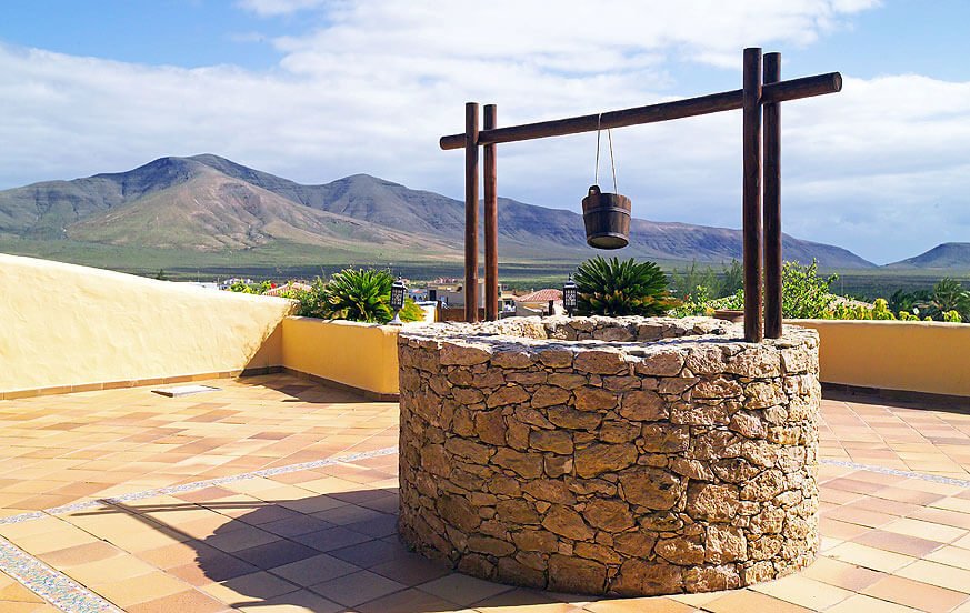 Rincón del patio con un antiguo pozo en Casa Rural Piedra Blanca Tahona