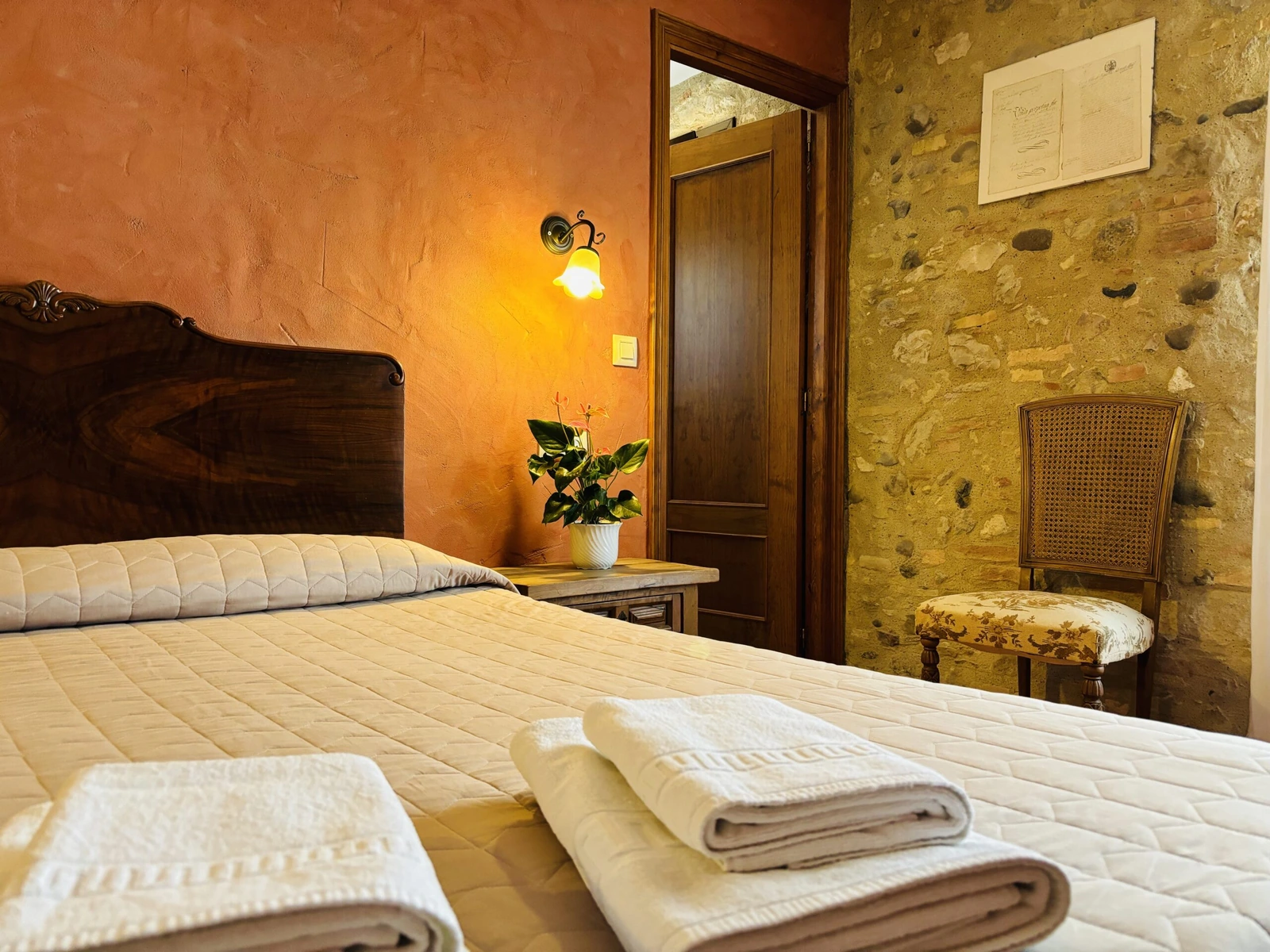 Fresa: dormitorio con paredes de piedra y tonos rojos. · Can Mas