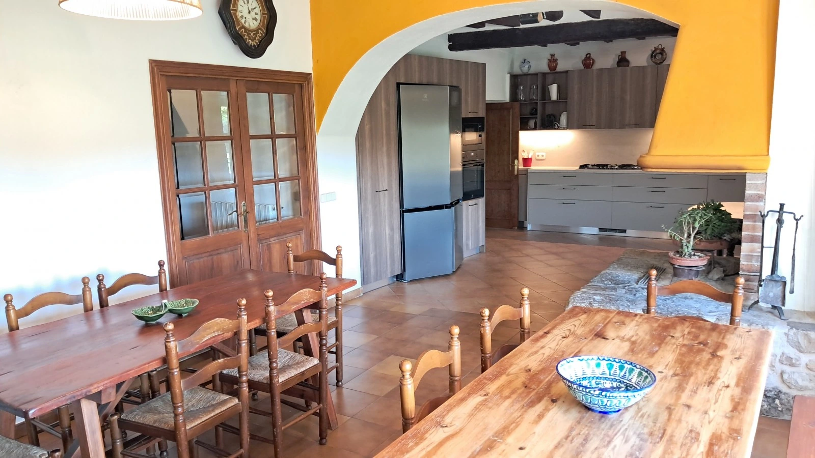 Cocina-comedor con mesa de madera y chimenea. · Can Masó