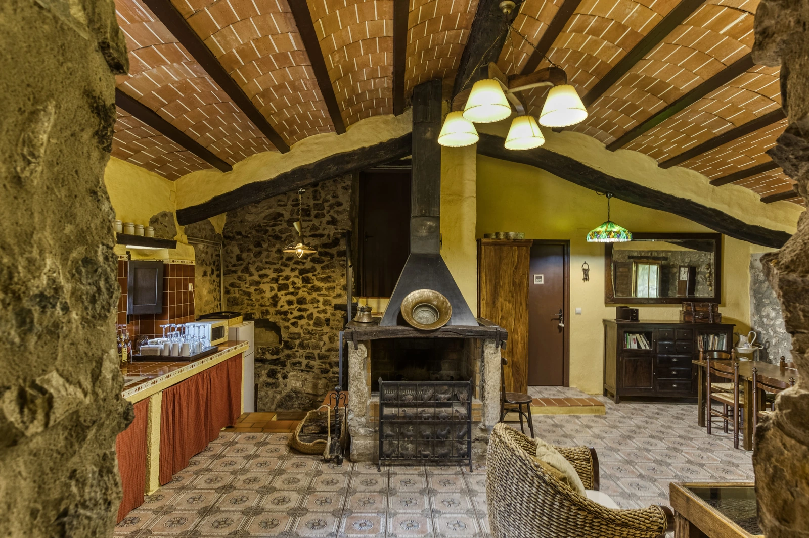 Sala común con chimenea central, mesas y zona de bar. · Can Pei
