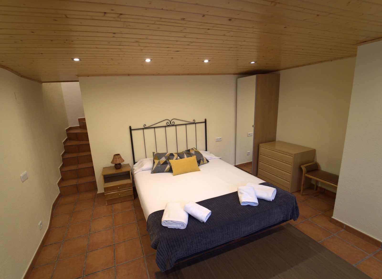 Dormitorio de El Pi, con cama doble y cabecero de hierro. · El Nou Can Peric