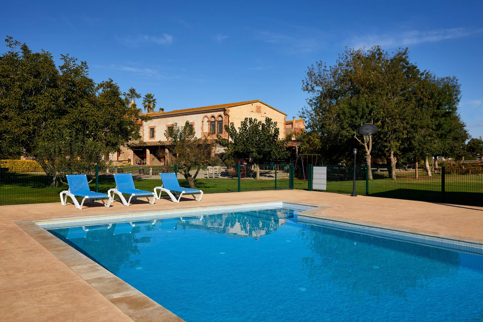 Can Pujol: piscina comunitaria y conjunto al fondo. · Can Pujol