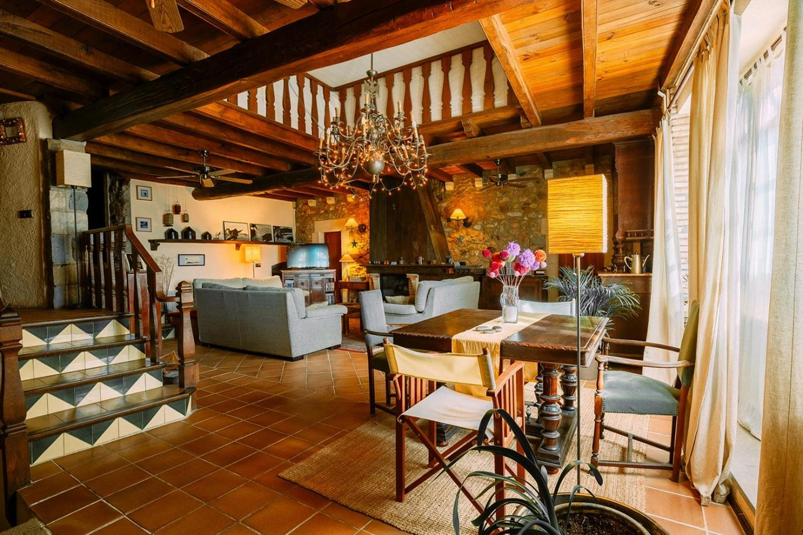 Salón y comedor comunes, con vigas y mesas. · Can Vila