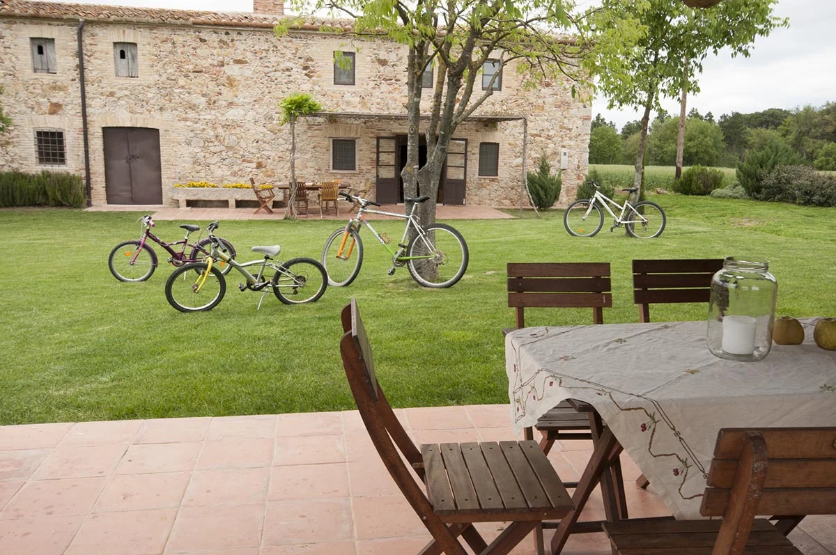 Jardín de La Casa Petita de Can Dalmau con bicicletas y zona de descanso