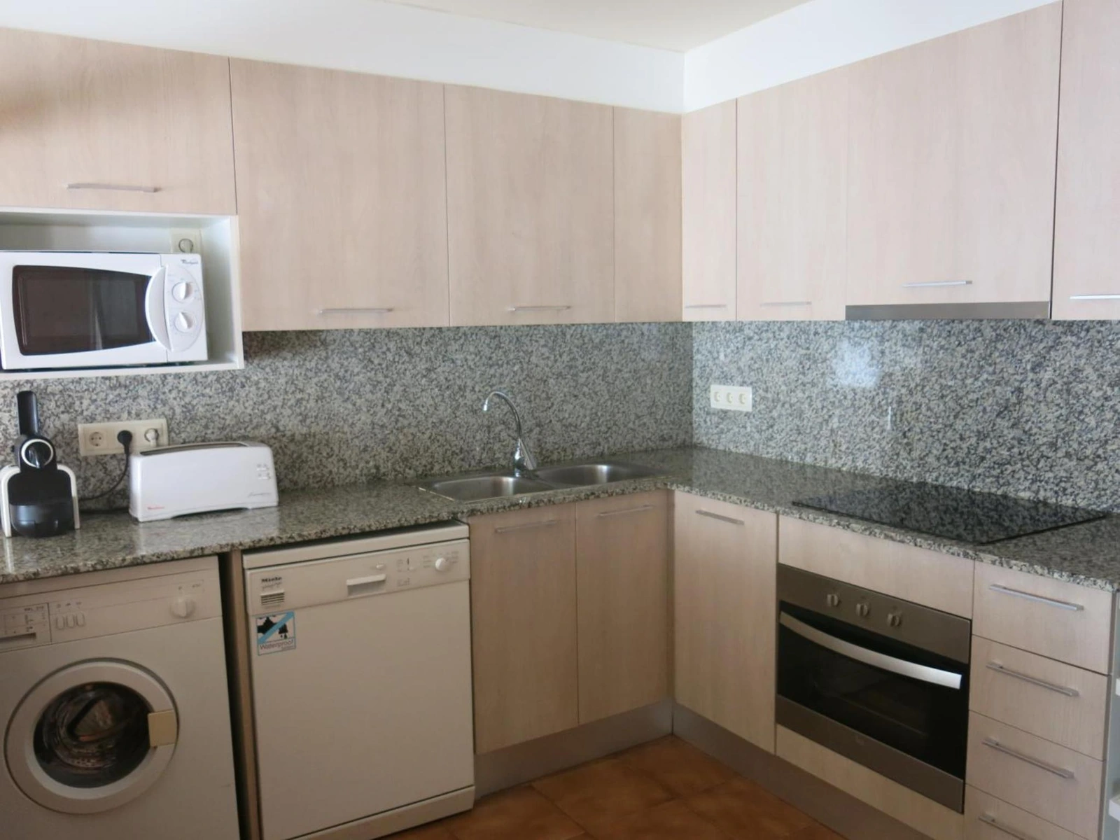 Cocina de la casita de tres habitaciones, con horno, lavavajillas y lavadora. · Les Barnedes