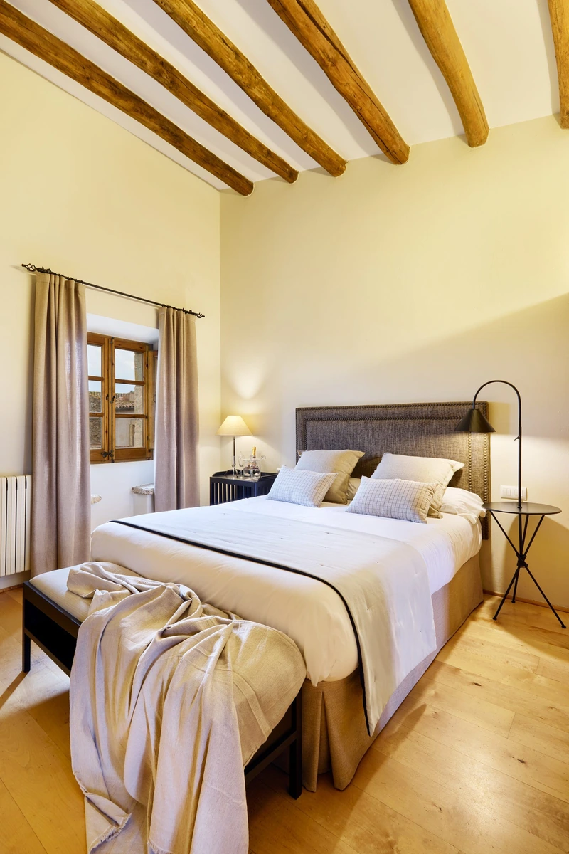 Llevant: dormitorio con vigas de madera. · Mas Ametller