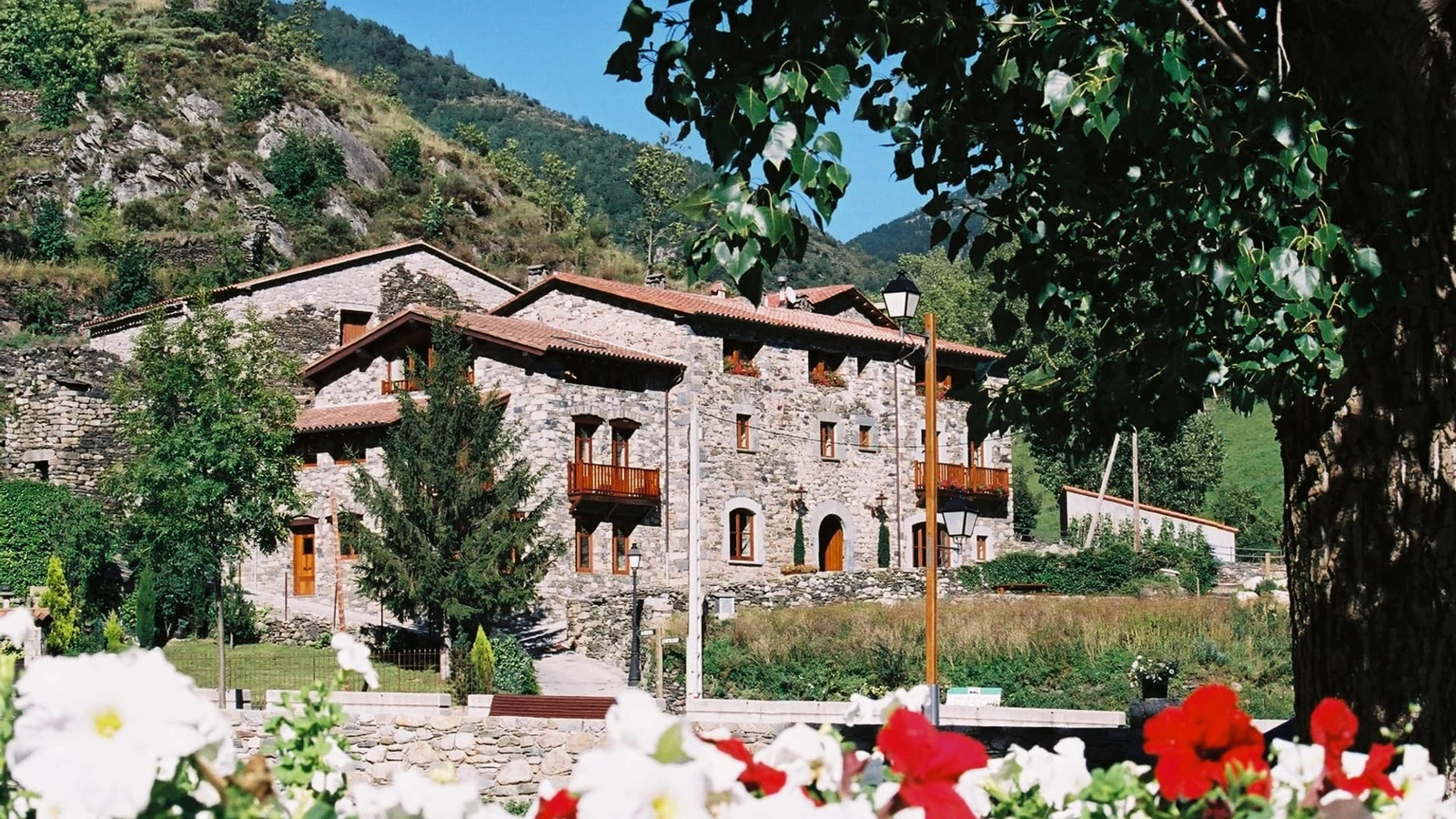 Mas Can Buixat: fachada de piedra y jardín. · Mas Can Buixat