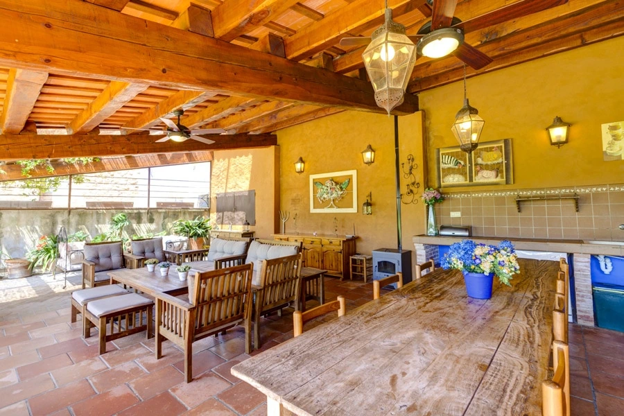 Porche compartido de Mas Petit con comedor, zona de estar y cocina común. · Mas Petit