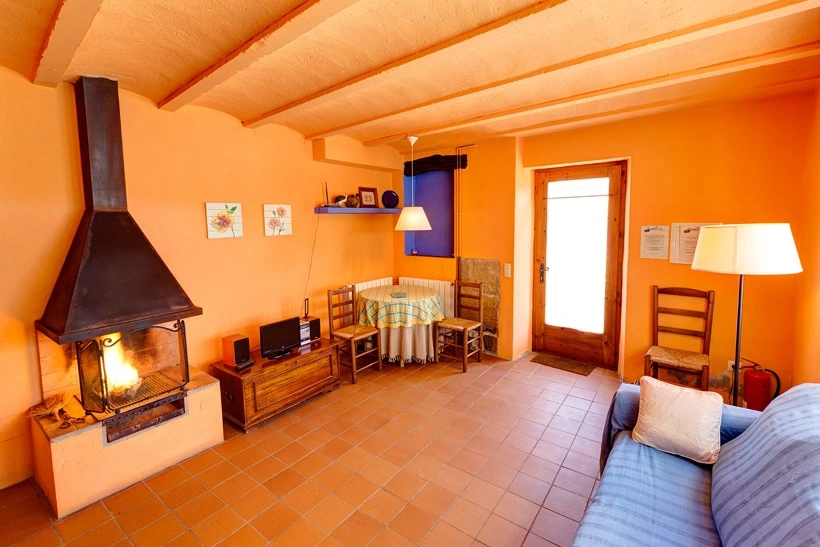 Sala de estar y comedor con chimenea del apartamento Garbí. · Mas Petit
