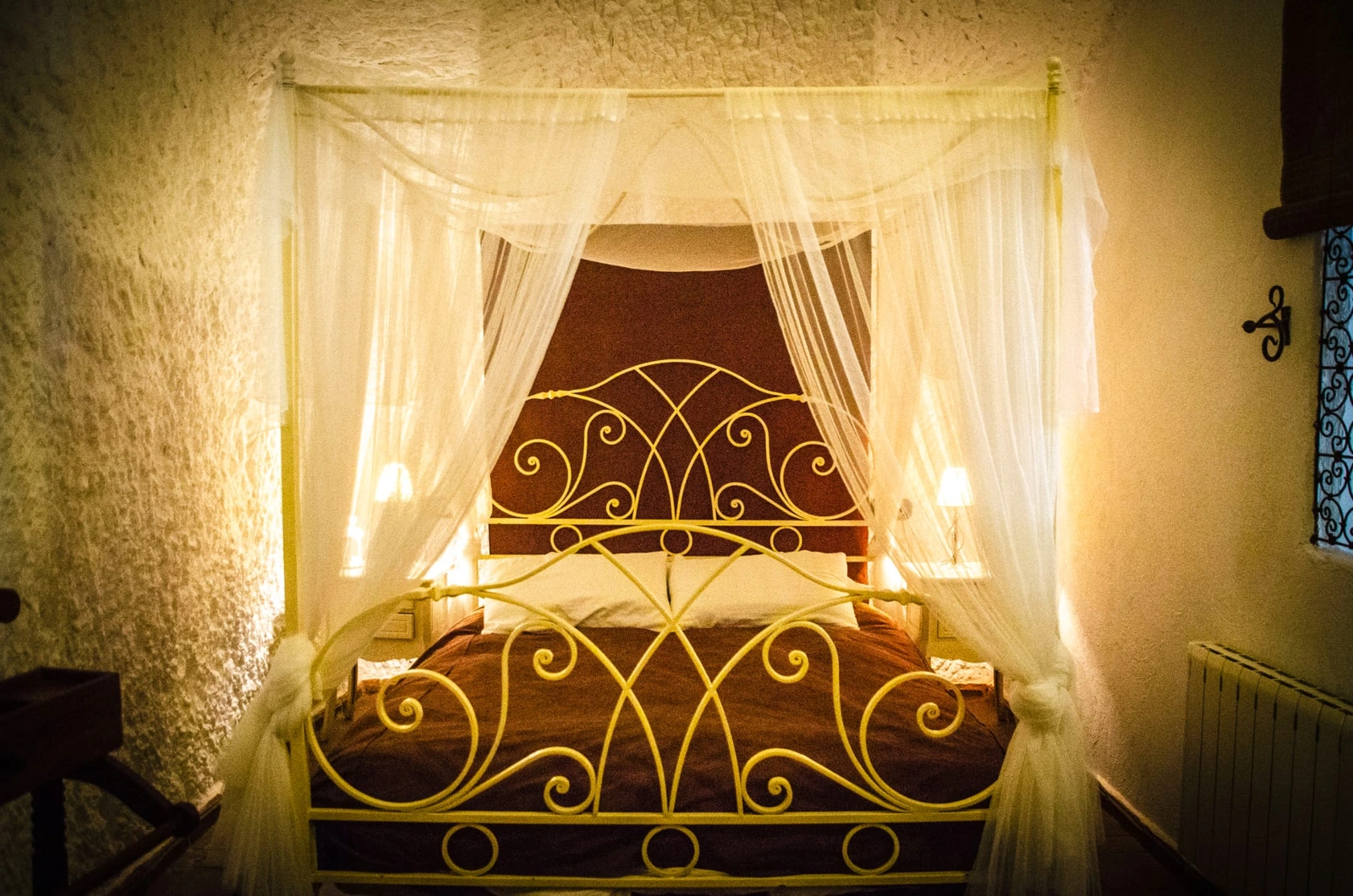 Dormitorio de casa cueva con cama de hierro y dosel; unidad sin identificar. · Cuevas Almagruz