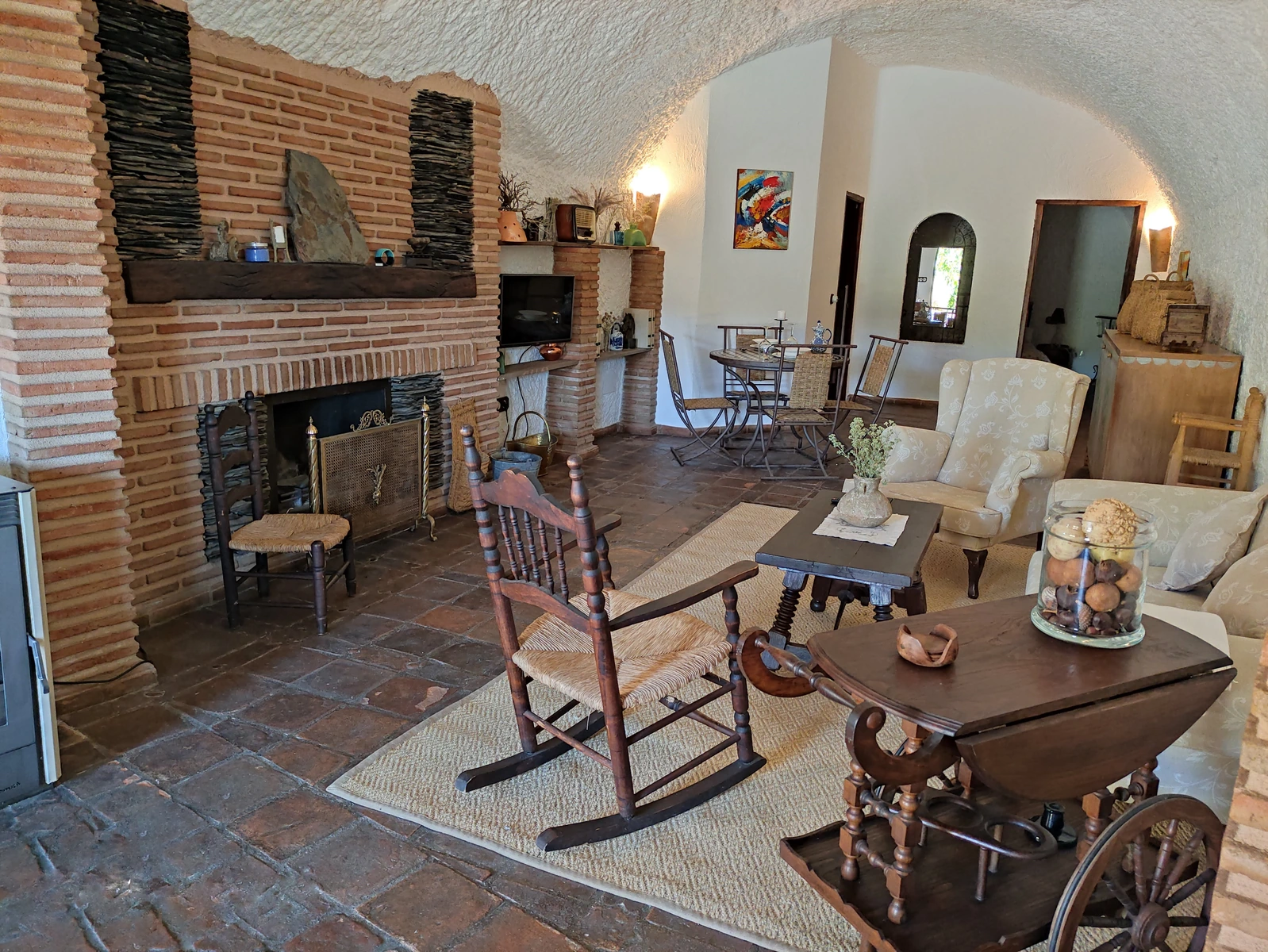 Salón de casa cueva con chimenea y comedor; unidad sin identificar. · Cuevas Almagruz
