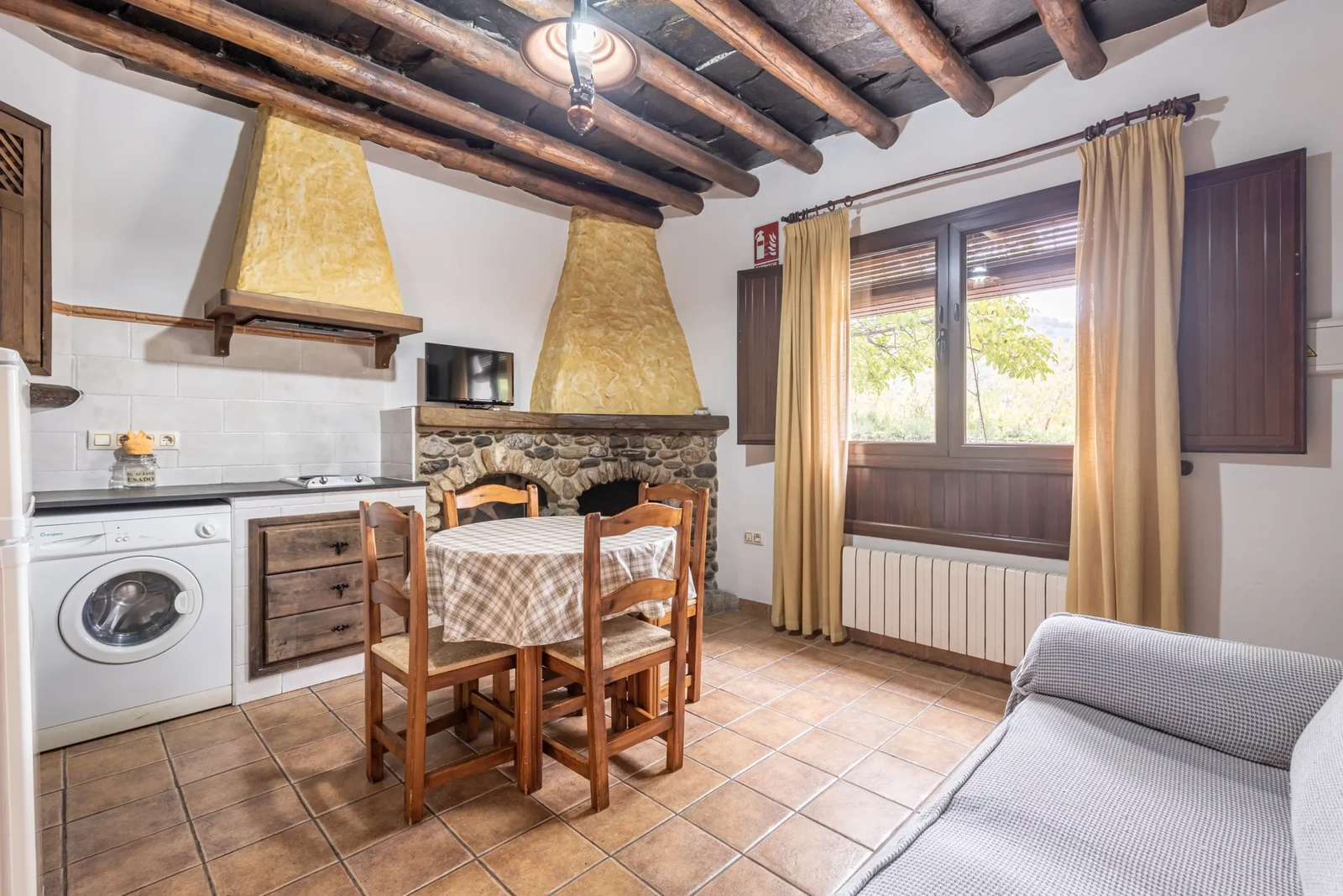 Salón, comedor y cocina de un apartamento de 2/4 plazas, junto a la chimenea. · El Cercado Turismo Rural & Spa
