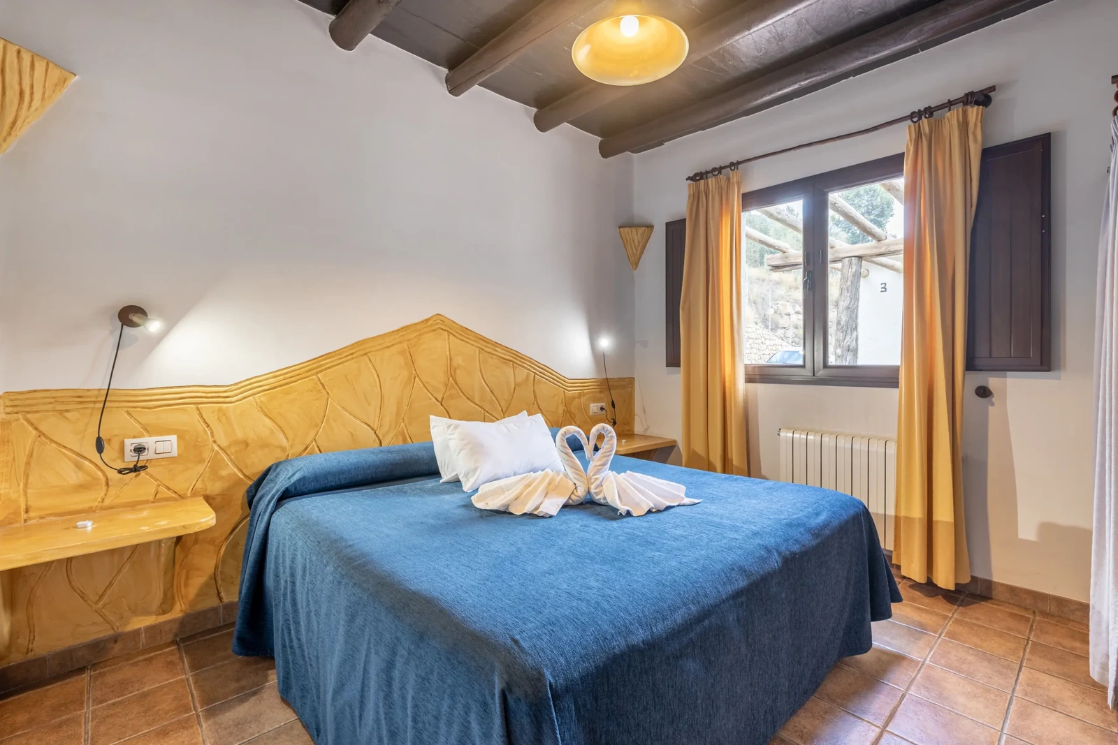 Dormitorio de un apartamento de 2/4 plazas, con cama doble y colcha azul. · El Cercado Turismo Rural & Spa