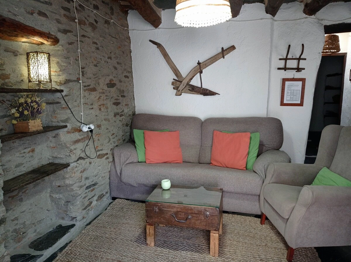 Salón con sofás y pared de piedra · La Abuela Mercedes