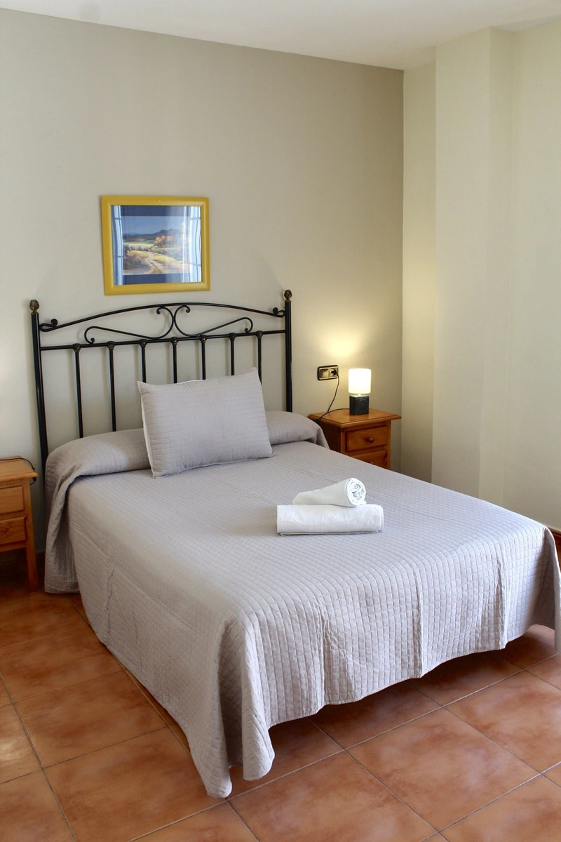 Habitación de la modalidad individual, con cabecero de hierro. · Quéntar Hotel Rural