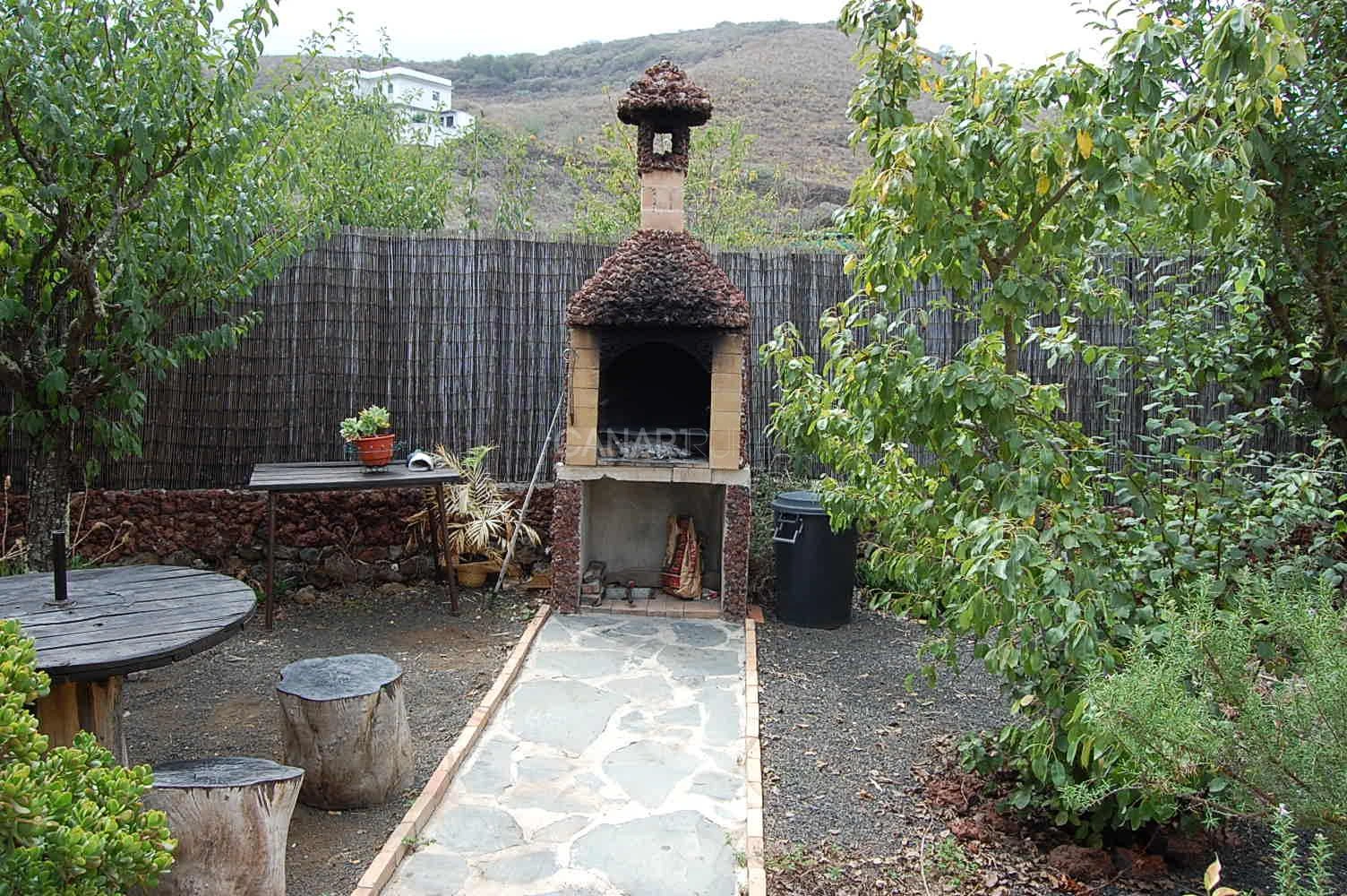 Barbacoa y mesas de madera en el jardín de La Asomada · Casa Rural La Asomada