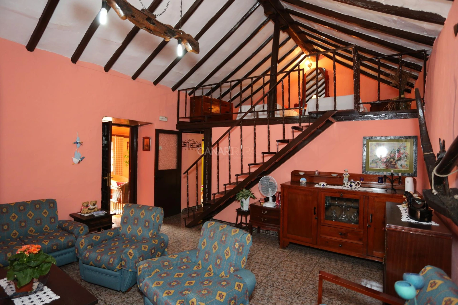 Salón de La Asomada y escalera hacia el dormitorio del altillo · Casa Rural La Asomada