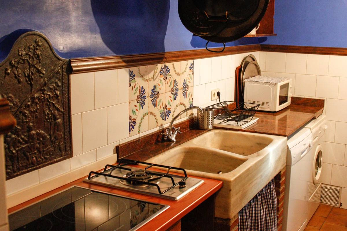 Cocina de Casa Andrea con paredes azules y fregadero de piedra · Casa Andrea