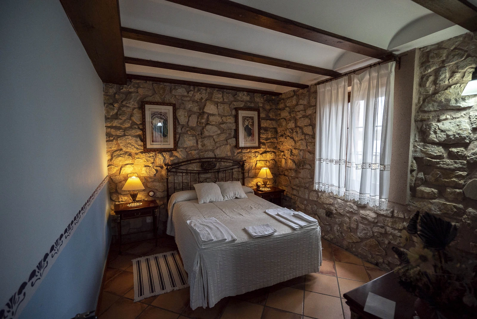 Habitación estándar con cama de matrimonio y pared de piedra. · El Molino del Batán
