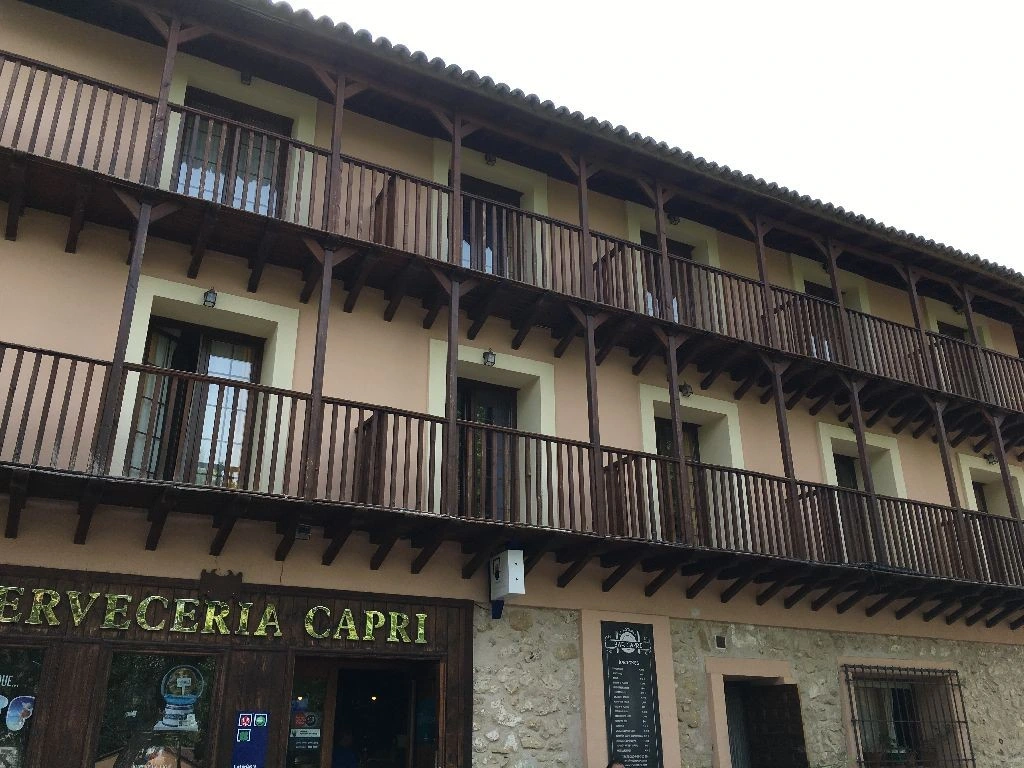 Fachada de La Botería con sus galerías de madera y el local Capri en planta baja · La Botería
