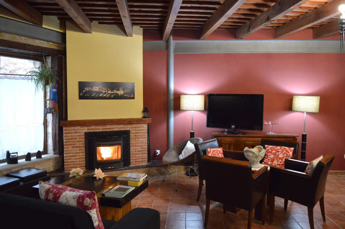 Salón común con chimenea y televisión · Posada Los Cuatro Caños