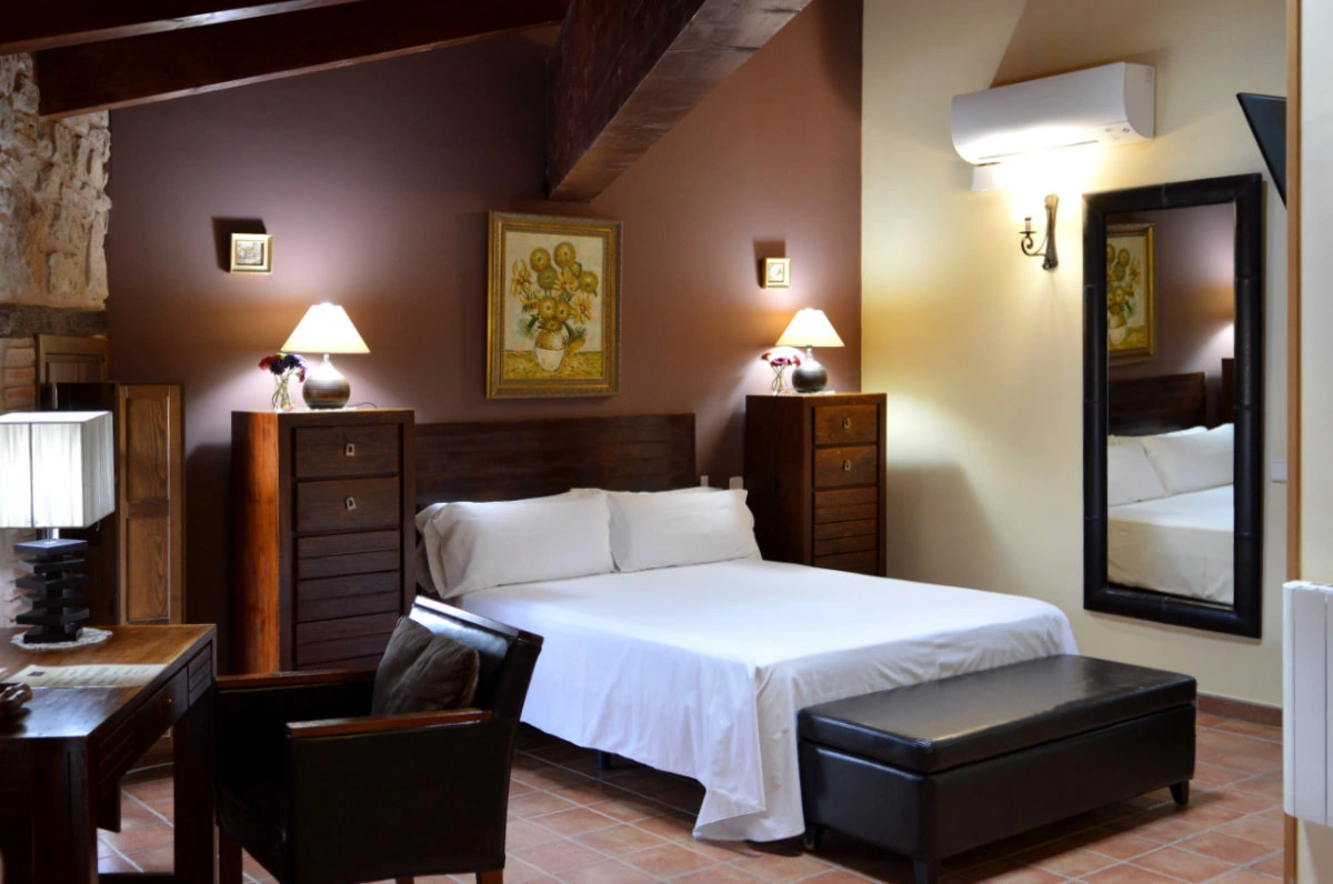 Travesaña Alta: dormitorio bajo vigas de madera · Posada Los Cuatro Caños
