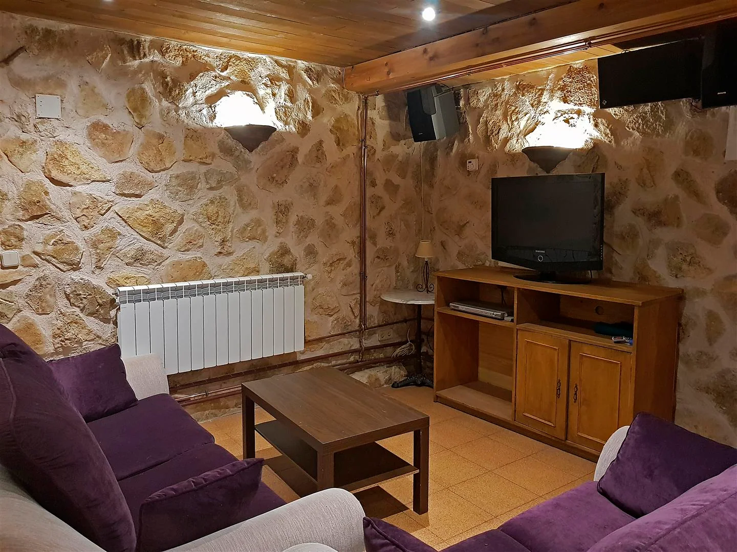 Salón de la bodega común con sofás y televisión