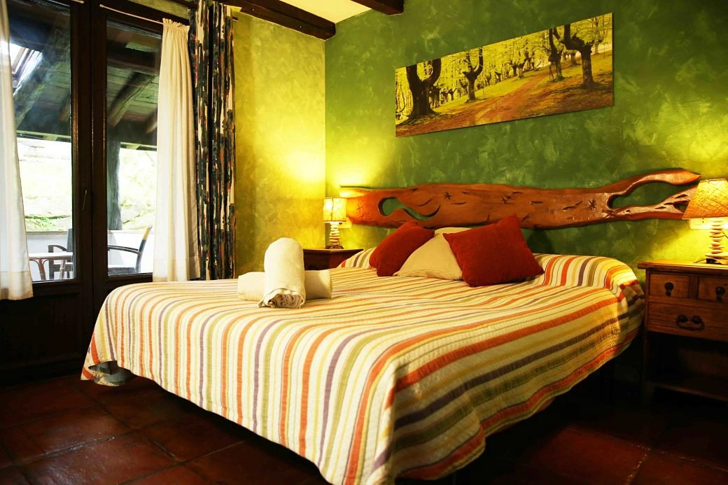 Habitación Donostia: dormitorio con salida al porche. · Agroturismo Maddiola