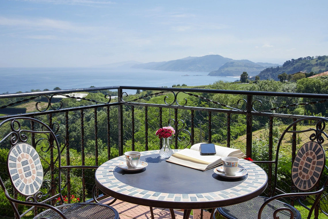 Terraza de Itxaso con mesa y vistas hacia la costa · Epotx Etxea
