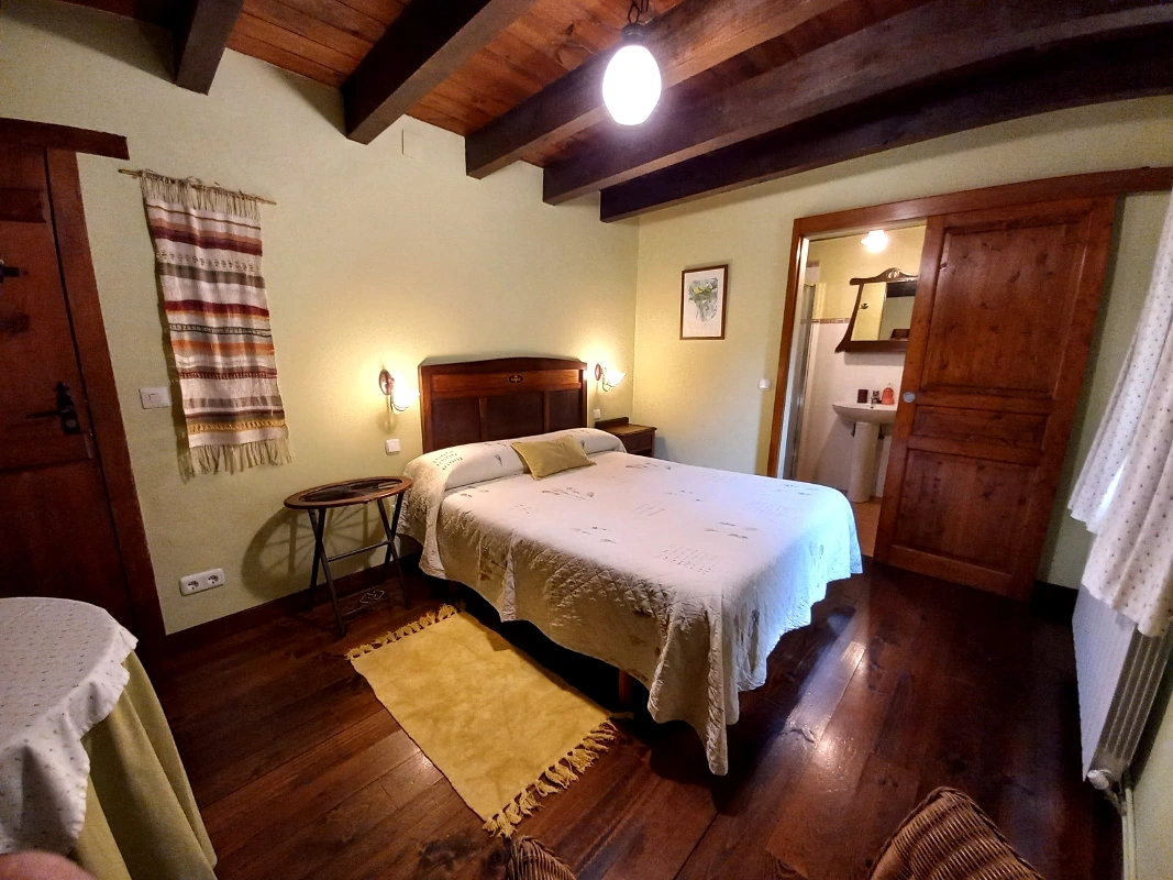Habitación nº 3 de Goikola, con cama doble y acceso visible a su baño privado. · Goikola