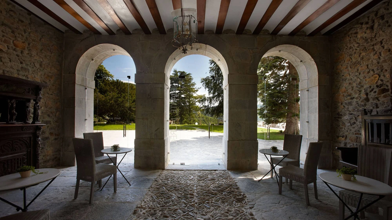 Entrada del hotel con tres arcos y vistas al jardín. · Iriarte Jauregia