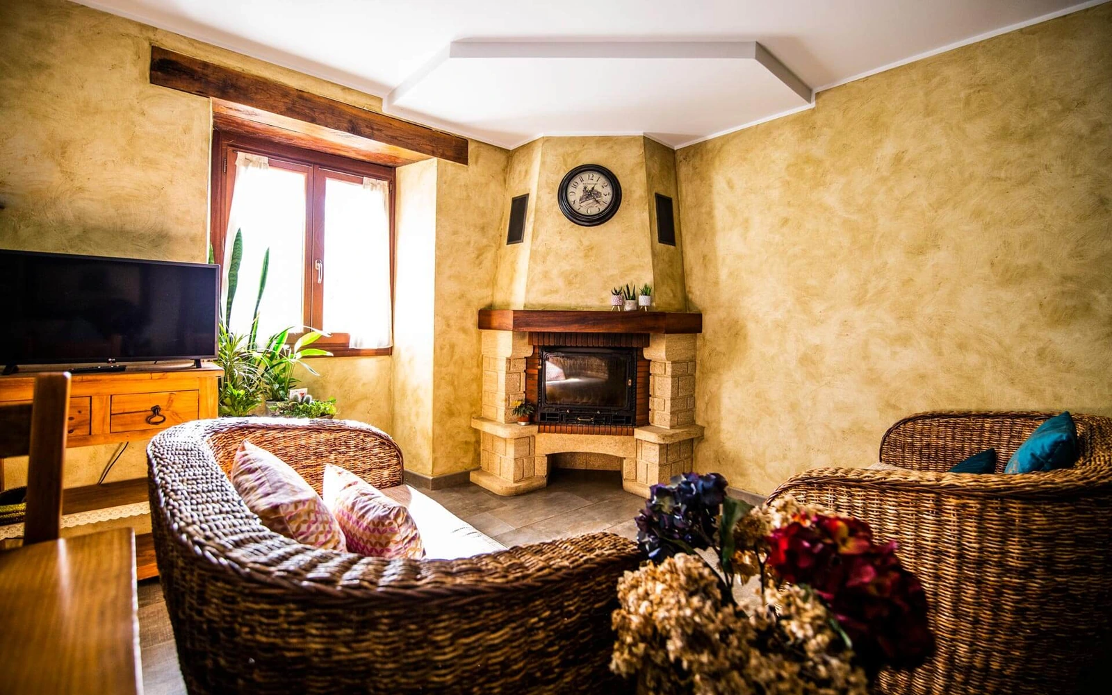 Salón compartido con chimenea y sillones de mimbre. · Agroturismo Korteta