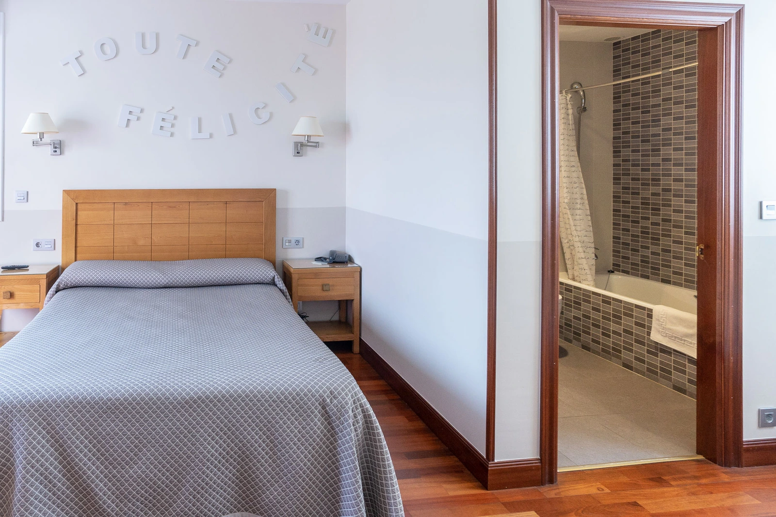 Dormitorio con baño al lado de la cama. · Hotel Leku Eder