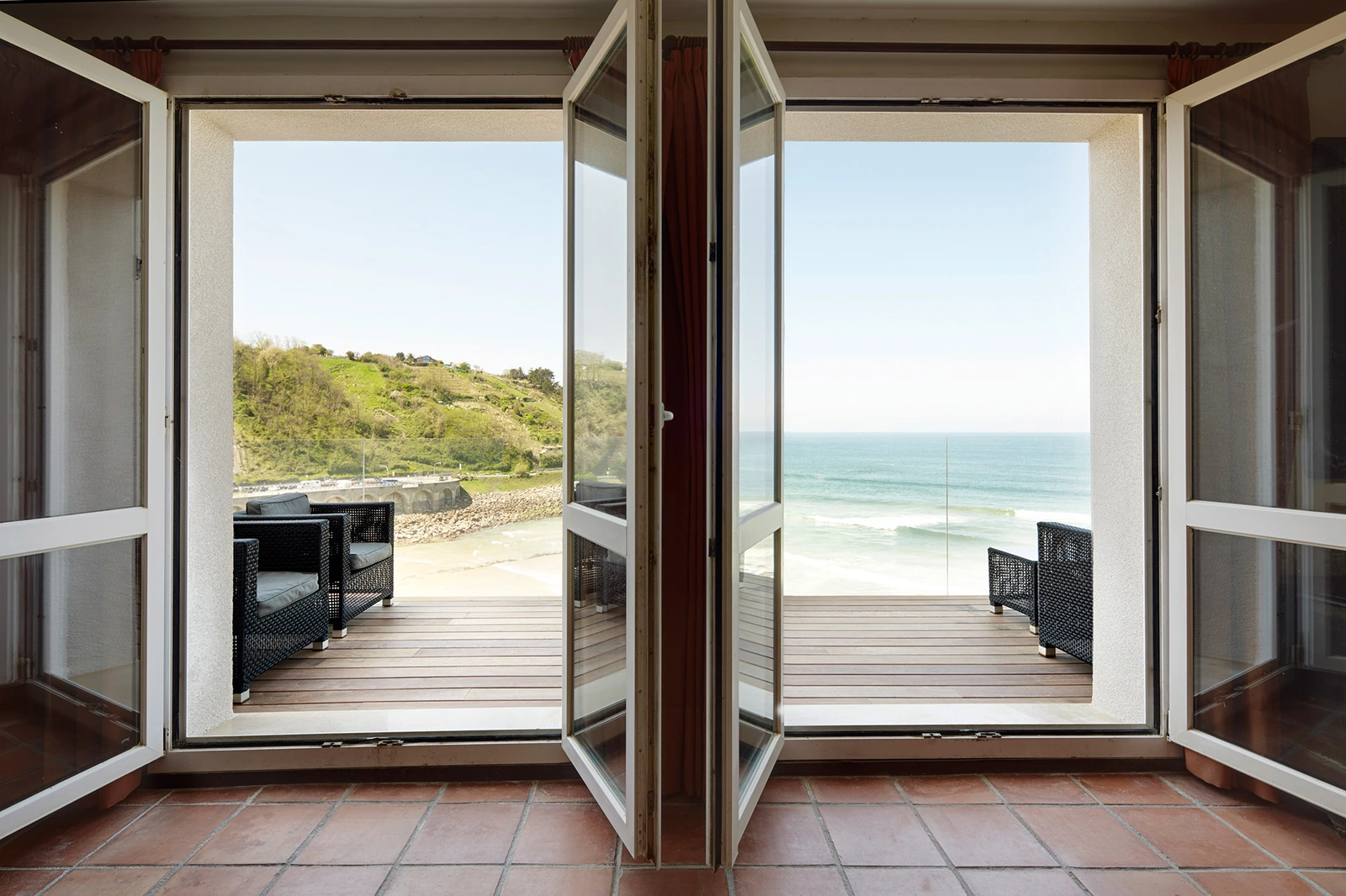 Terraza del hotel vista desde el interior, con asientos frente al mar · Saiaz Getaria Hotela