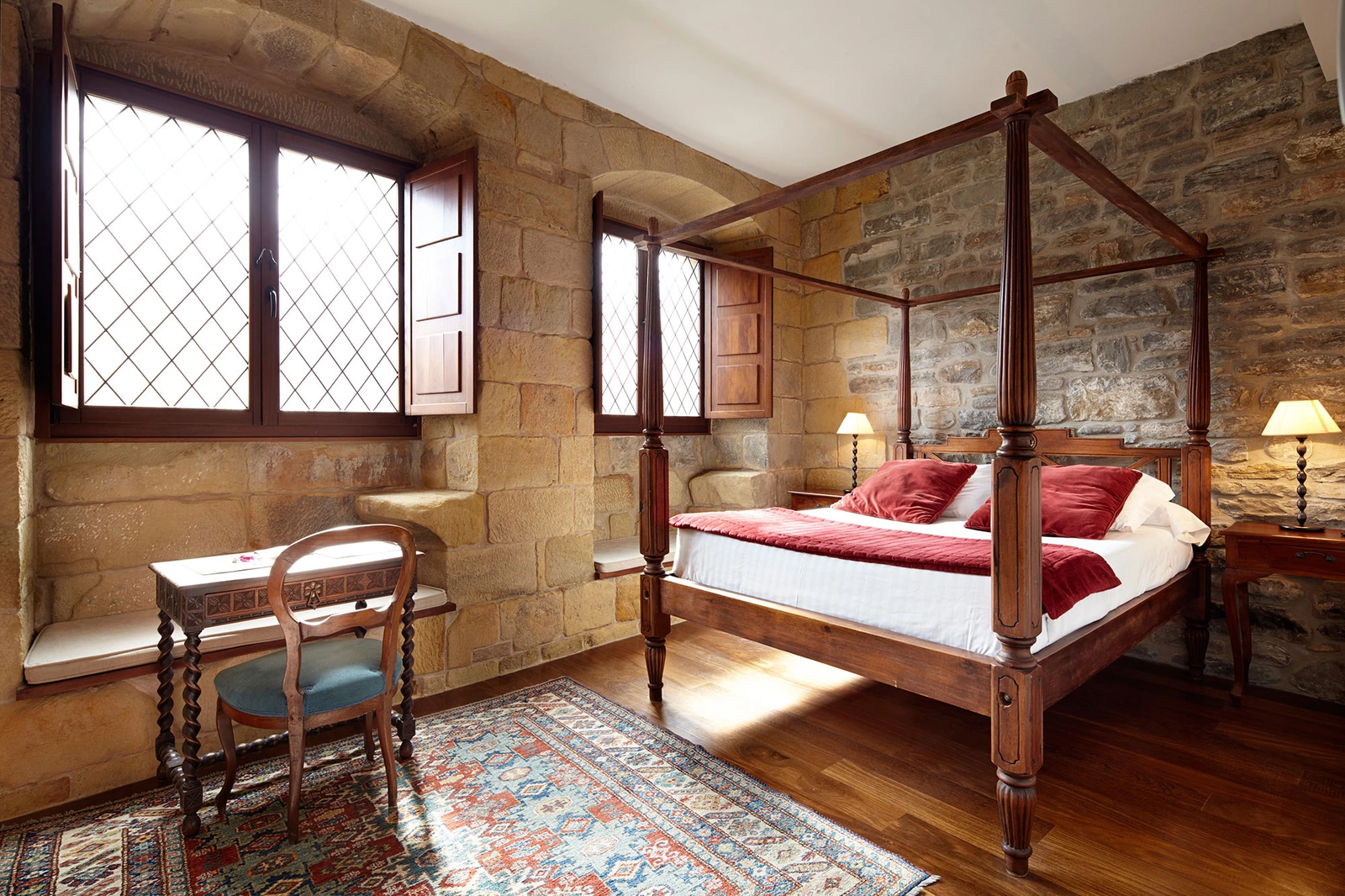 Dormitorio de piedra con cama de dosel en Saiaz Getaria Hotela · Saiaz Getaria Hotela
