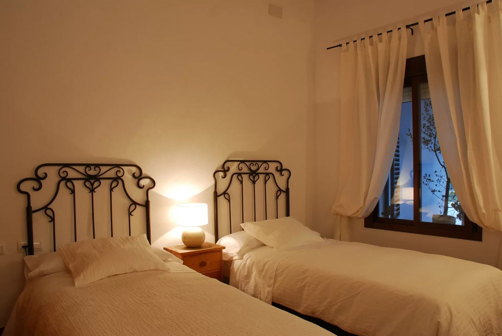 Dormitorio twin de Valde Junco, luz cálida · Posadas de Valdelarco