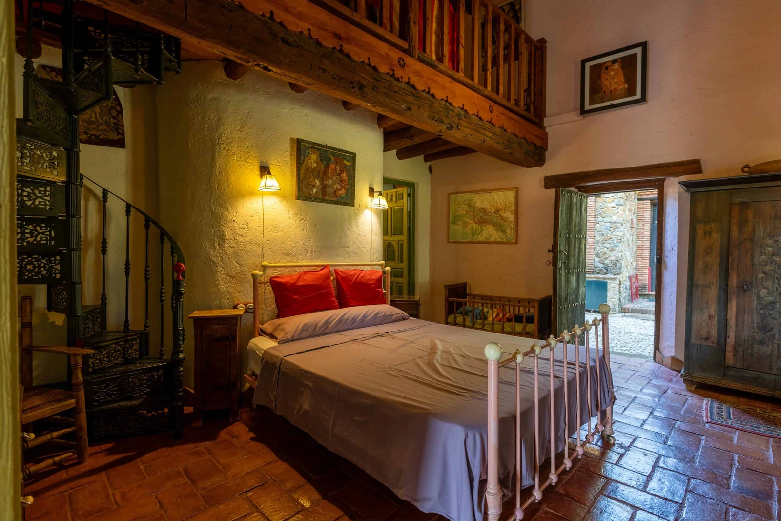 El Águila: dormitorio de matrimonio y escalera a la galería. · Molino Río Alájar