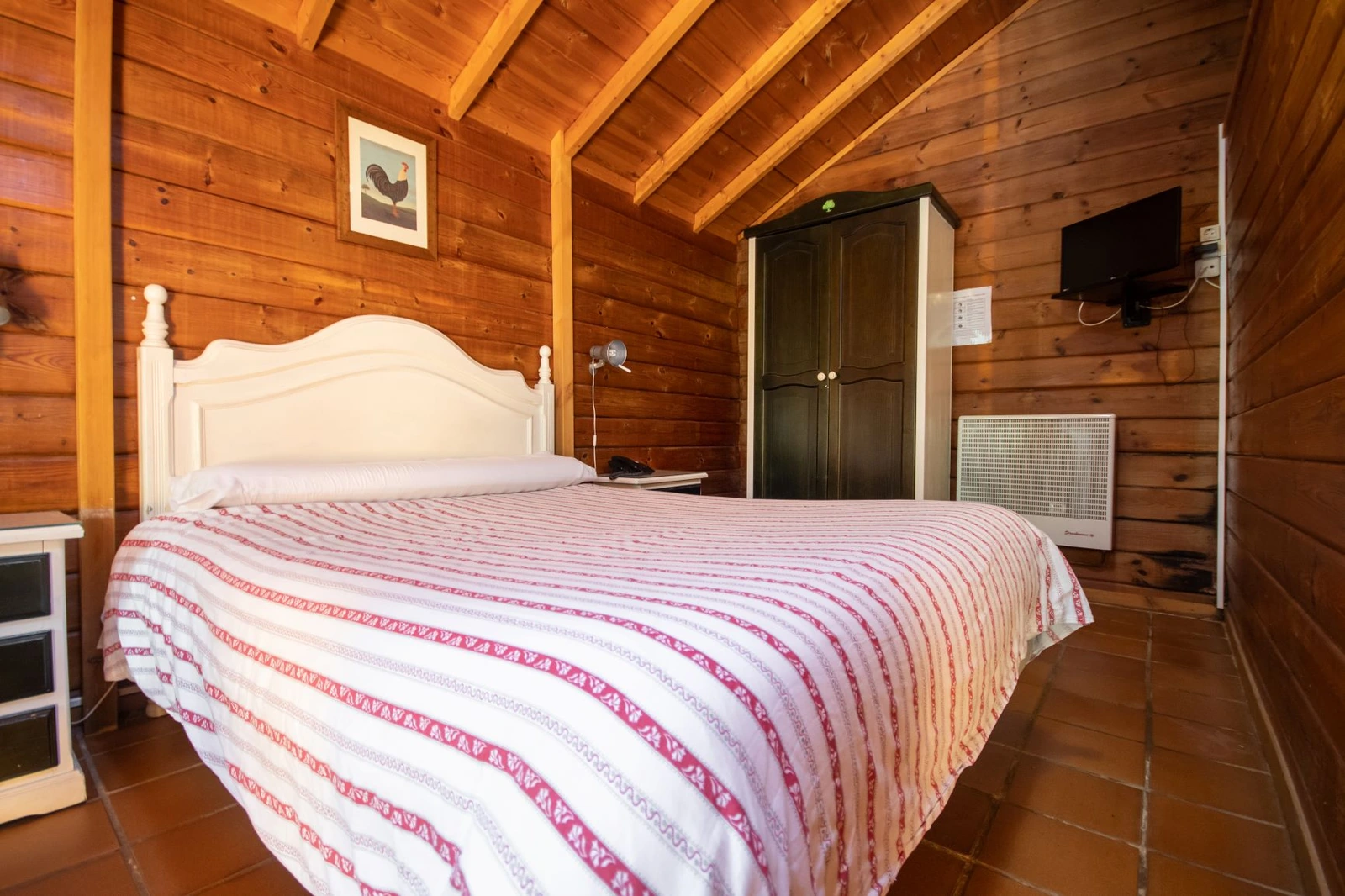 Dormitorio con cama de matrimonio en una cabaña de madera · Posada de Cortegana