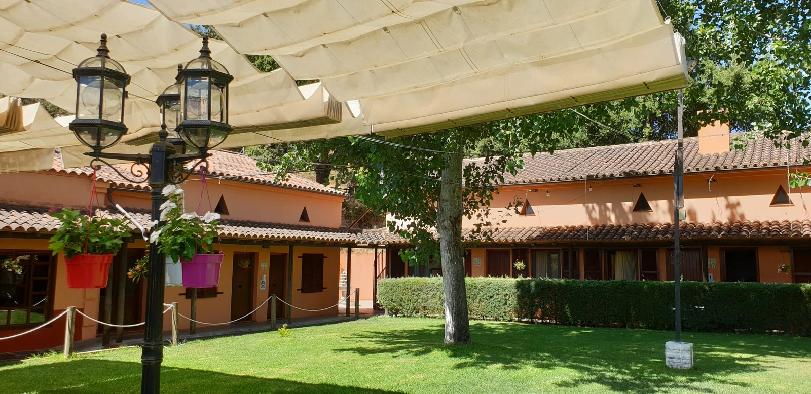 Jardín central rodeado por los bloques de habitaciones. · Posada El Camino Almonaster